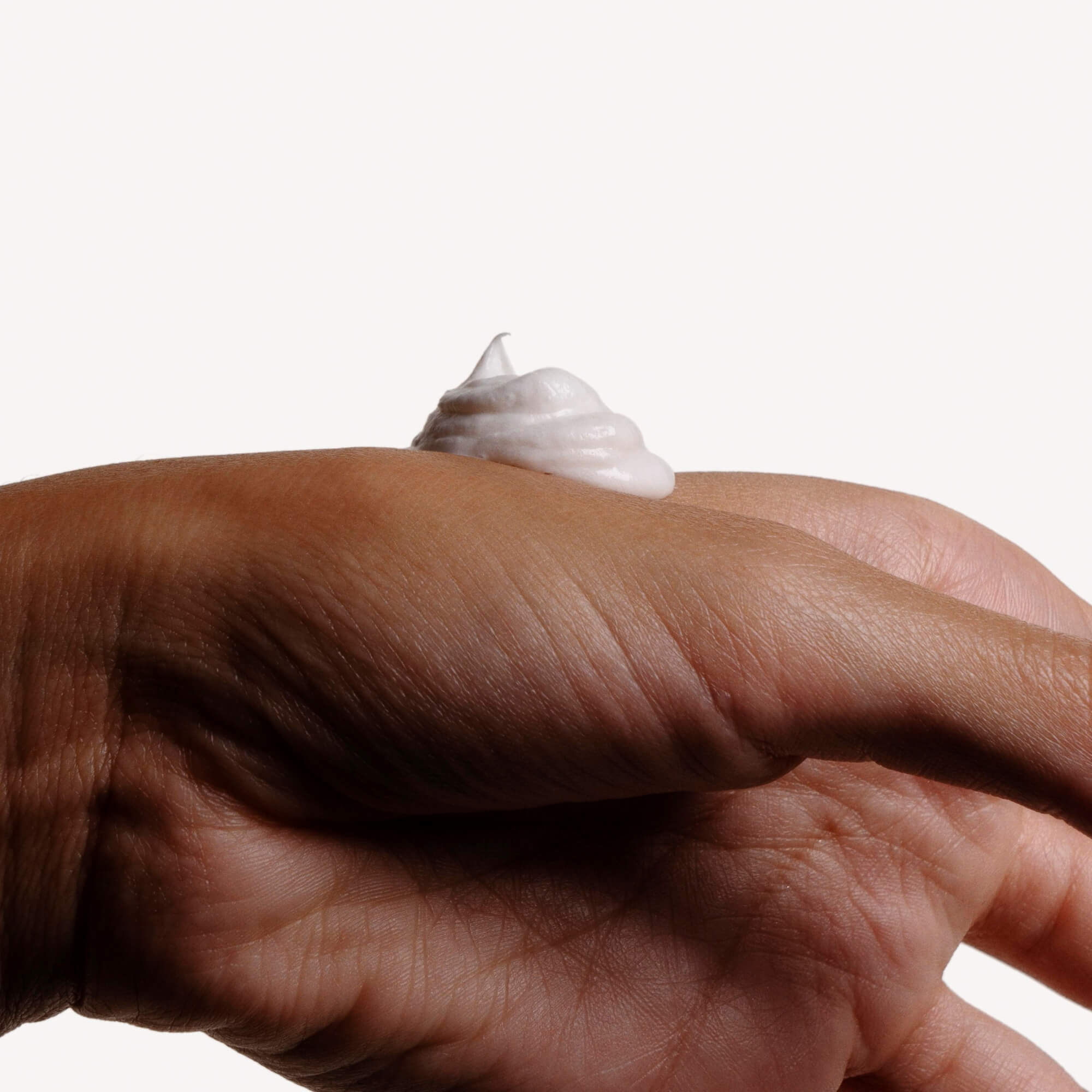 Textura de la crema facial Évanescente de COTTAN aplicada sobre la piel, que muestra una textura ligera, fundente y de rápida absorción.