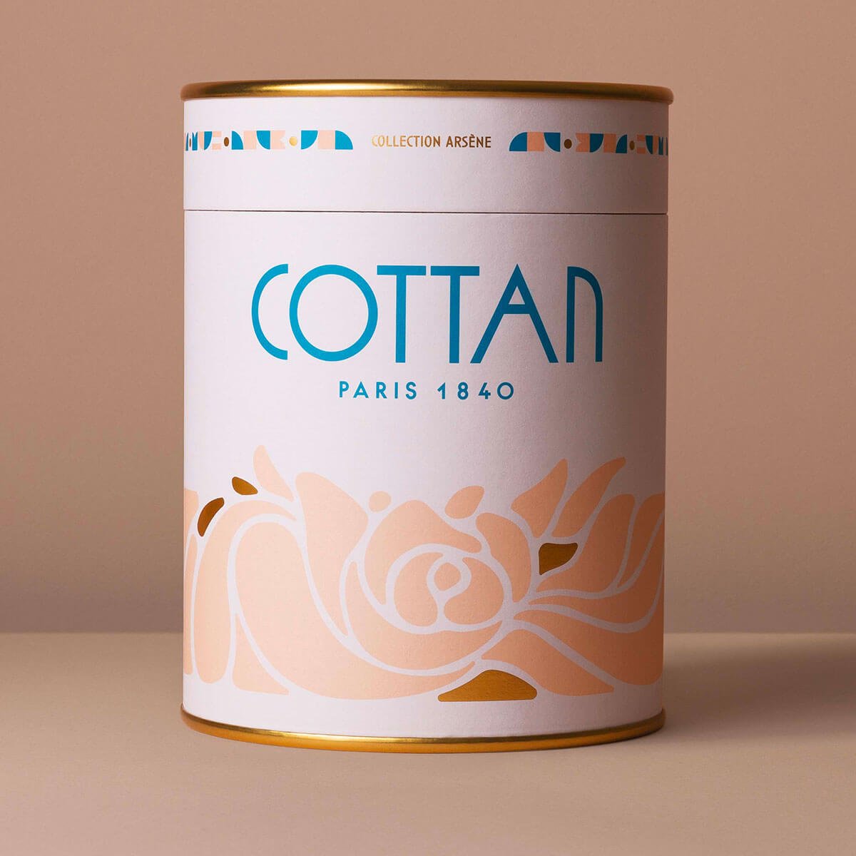 Vista del producto en el estuche cilíndrico del cofre regalo Arsène COTTAN Paris 1840. El cofre metálico, decorado con delicados motivos y acabados dorados, encarna la herencia y la elegancia atemporal de la casa COTTAN.